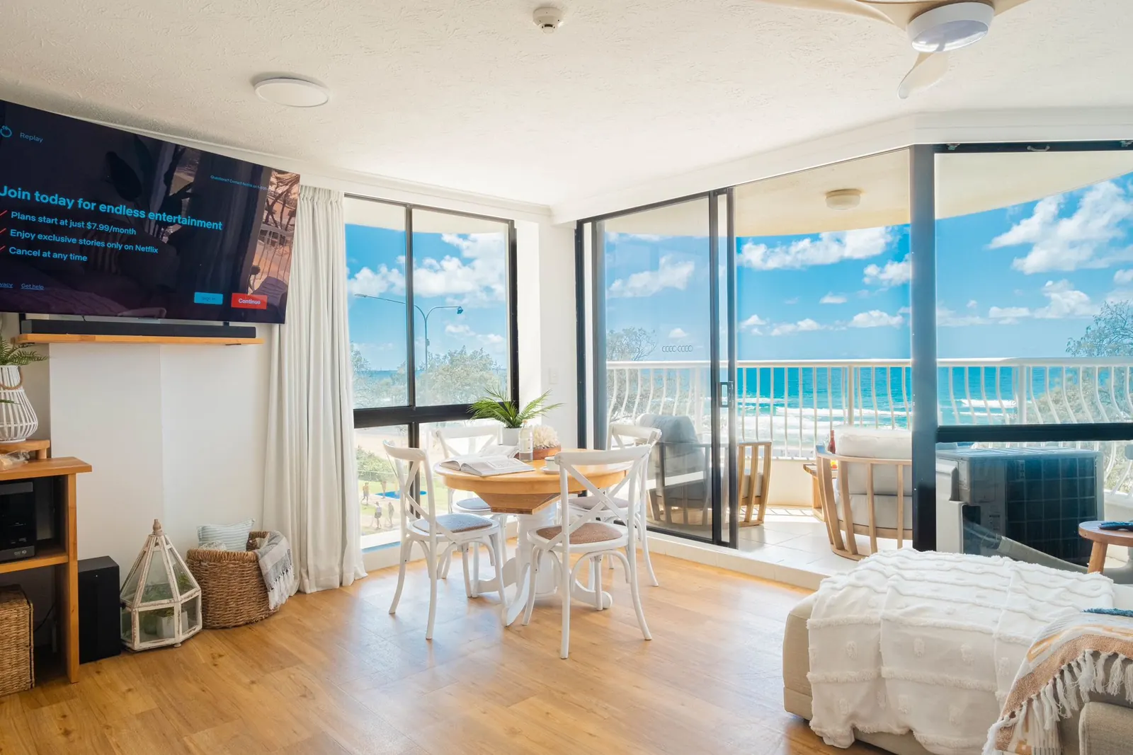 Open-plan living and dining room with ocean views through the glass